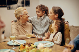 Women's Health and Hormonal Imbalances. Happy female members of extended family communicating during a meal in dining room.