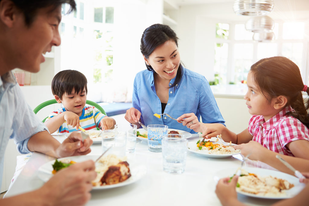 Asian Family Sitting At Table Eating Meal Together after meal planning