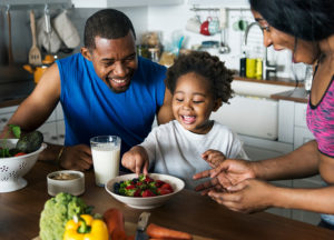 Pediatric Nutrition. Black family eating healthy food together