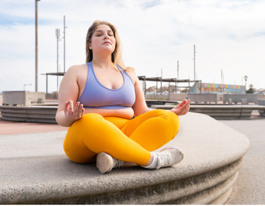 a woman sits in a lotus position with her eyes closed