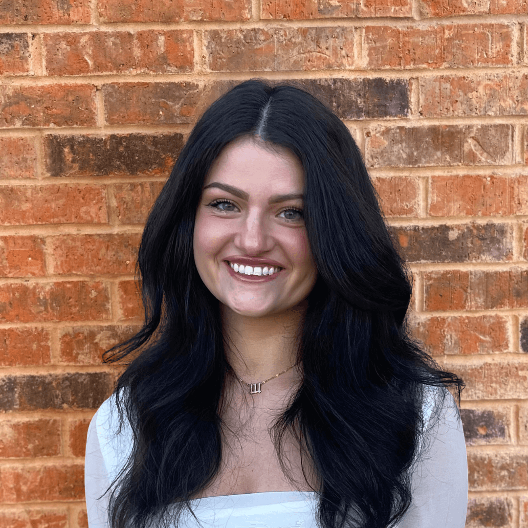 Bella Fleps smiling in front of a brick wall