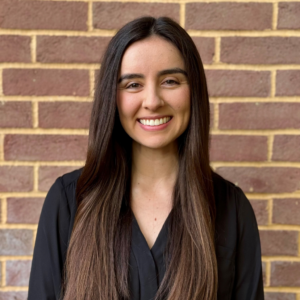 Alejandra Amezola-Velazquez smiling in front of a brick wall