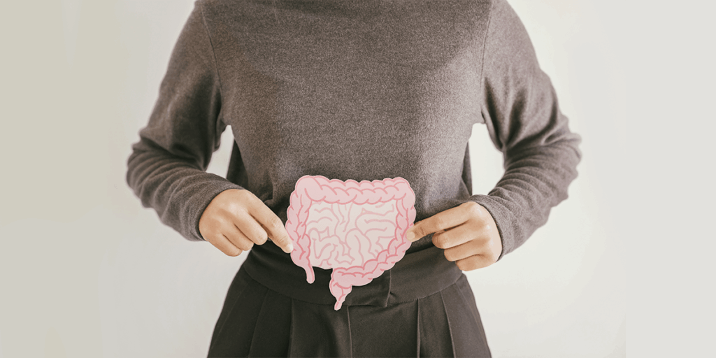 a woman holding a cardboard drawing of intestines