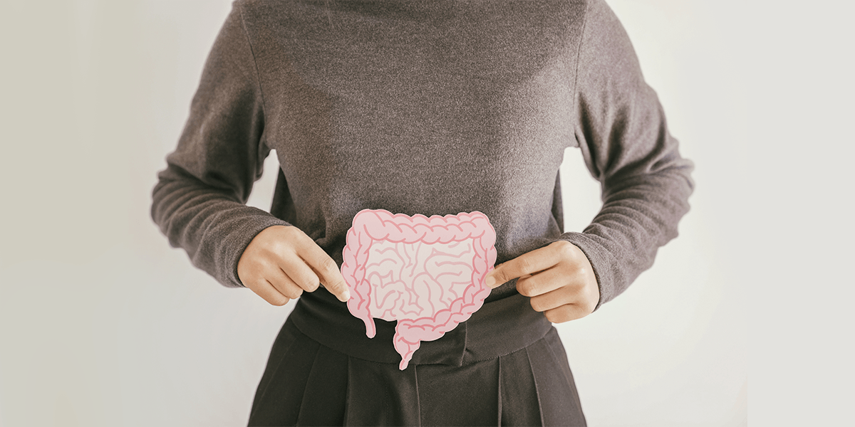 a woman holding a cardboard drawing of intestines